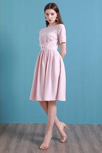 Upgrade your summer wardrobe with the elegant and sophisticated Robe Dahlia. This dress features a high-end Hepburn style, one-line collar, and a medium length pleated skirt for a flattering fit. Perfect for any occasion, this dress exudes timeless femininity in a soft pink color. Stay stylish and comfortable in this must-have dress.