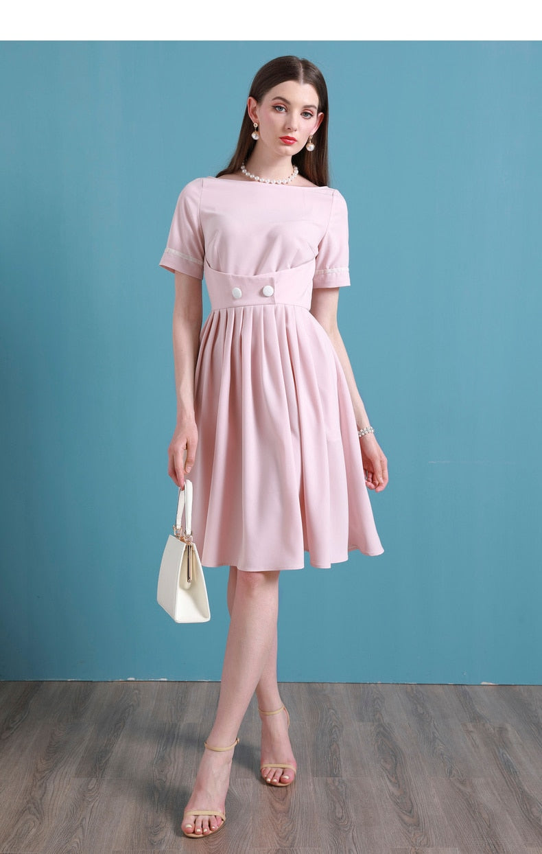 Upgrade your summer wardrobe with the elegant and sophisticated Robe Dahlia. This dress features a high-end Hepburn style, one-line collar, and a medium length pleated skirt for a flattering fit. Perfect for any occasion, this dress exudes timeless femininity in a soft pink color. Stay stylish and comfortable in this must-have dress.