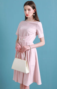 Upgrade your summer wardrobe with the elegant and sophisticated Robe Dahlia. This dress features a high-end Hepburn style, one-line collar, and a medium length pleated skirt for a flattering fit. Perfect for any occasion, this dress exudes timeless femininity in a soft pink color. Stay stylish and comfortable in this must-have dress.