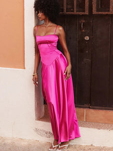 Indulge in elegant luxury with our Robe Anabella. Crafted from a sumptuous fuchsia satin, this flowing robe features a flattering neckline and delicate rouleau straps. The curved hem and corset-inspired lace-up back add a touch of vintage glamour, while the skirt drapes gracefully to the floor. Complete the look with matching heels for a truly regal ensemble.