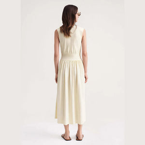 Indulge in luxury with our Robe Yolanda. This minimalist dress for women features a waist-slimming A-line silhouette and a flared midi skirt, accentuated by a vanilla white cotton fabric. The classic round neckline and sleeveless design add a touch of sophistication to this must-have summer piece.