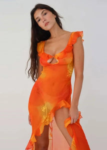 This stunning Dress Sunset features a vibrant orange tie-dyed print, perfect for those sunny summer days. The low cut back and backless design add a touch of allure, while the ruffle and high split details give it a chic and feminine look. Elevate your style and turn heads at any party or evening event with this eye-catching dress.