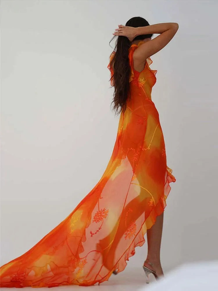 This stunning Dress Sunset features a vibrant orange tie-dyed print, perfect for those sunny summer days. The low cut back and backless design add a touch of allure, while the ruffle and high split details give it a chic and feminine look. Elevate your style and turn heads at any party or evening event with this eye-catching dress.