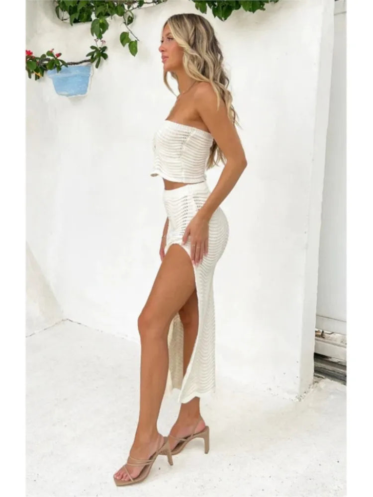 Revamp your wardrobe with the Ensemble Emma 2-piece set. Crafted with knitted fabric, this set features a stylish strapless crop top and a matching skirt with a split wrap design. The hollow out details add a touch of elegance to the overall look. Feel fashionable and confident in this versatile and trendy outfit.